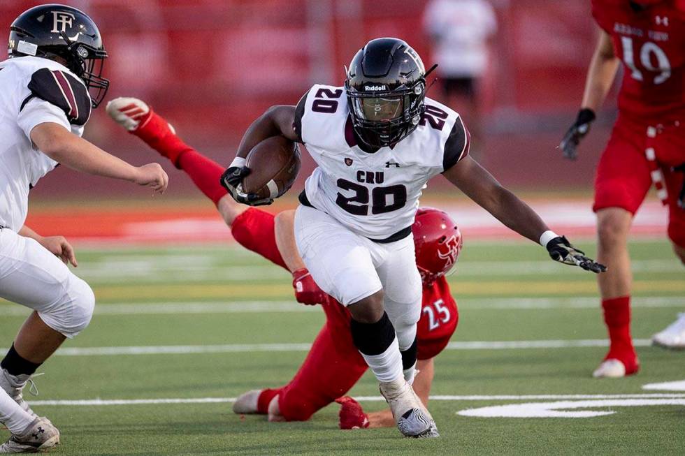 Faith Lutheran's Drais Bellamy (20) breaks a tackle from Arbor View's Tanner Aitken (25) during ...