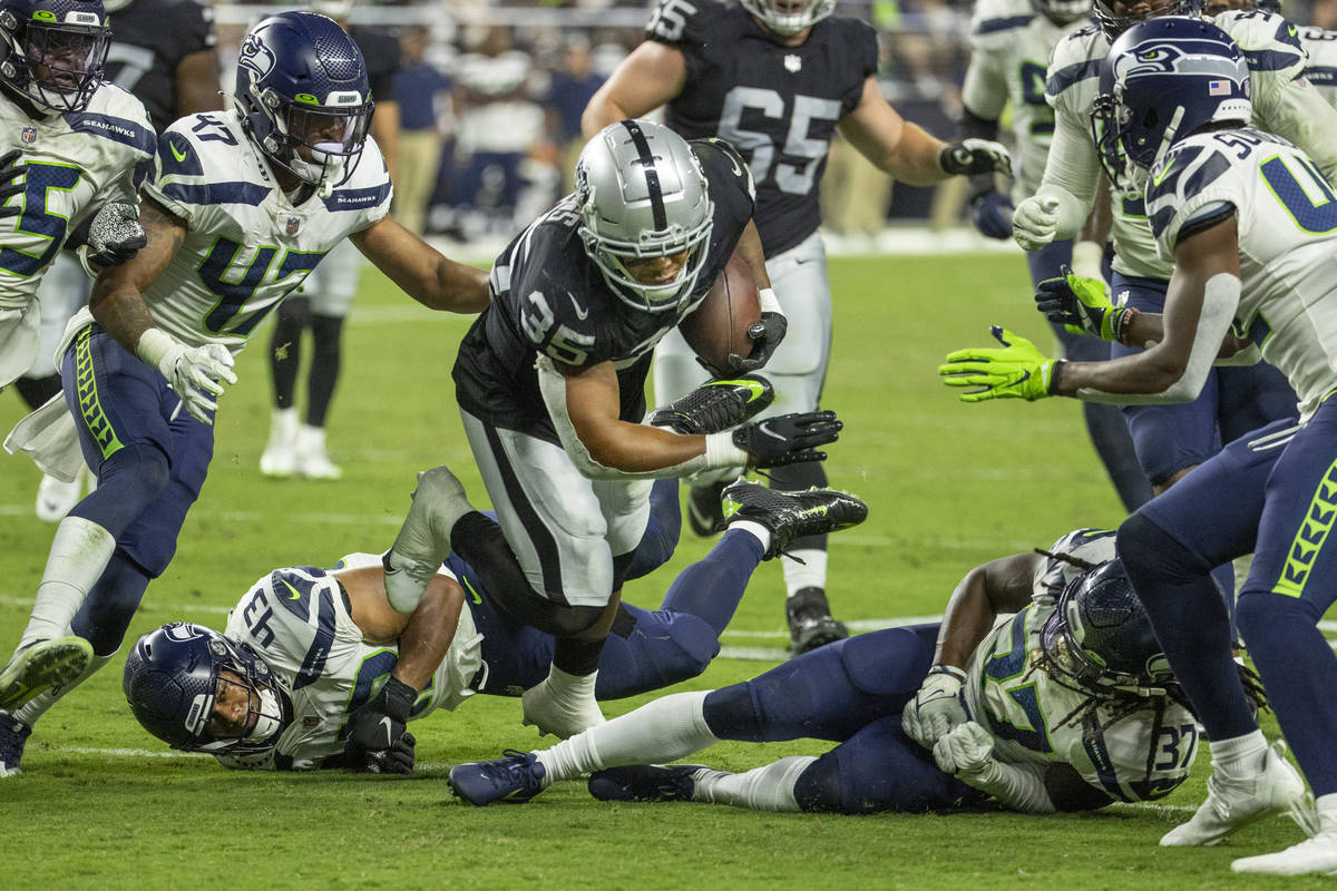 Raiders running back B.J. Emmons (35) breaks tackles by Seattle Seahawks linebacker Aaron Donko ...