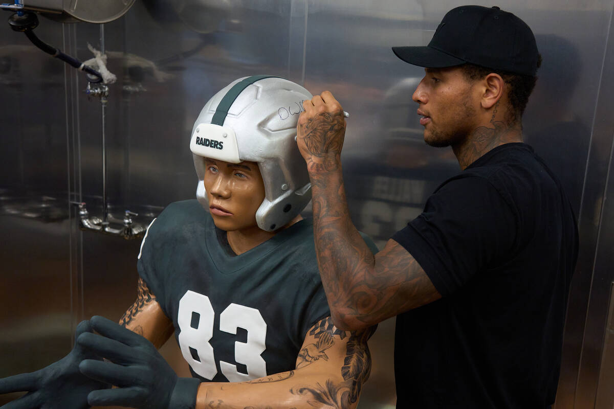 Raiders Darren Waller signs helmet of a chocolate statue of himself that will go on display at ...