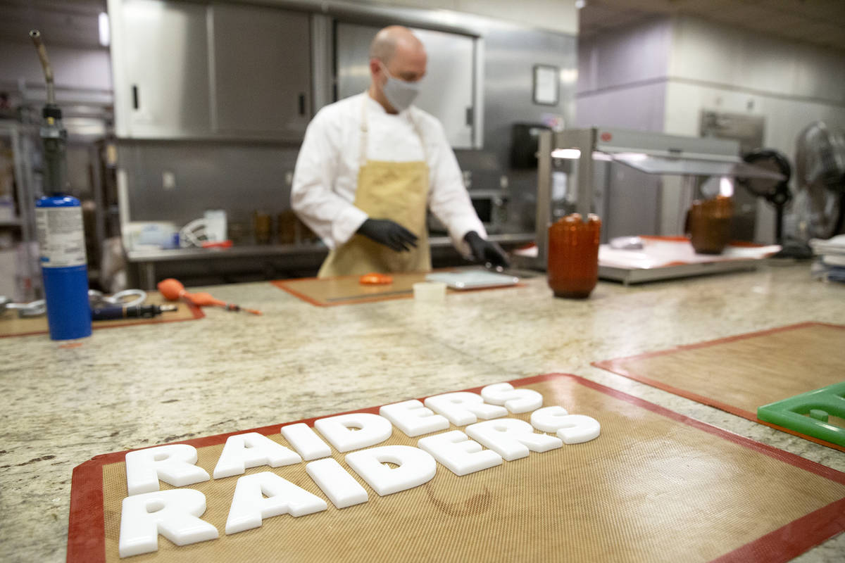 Executive pastry chef Mathieu Lavallee works in the background as Raiders lettering made of sug ...