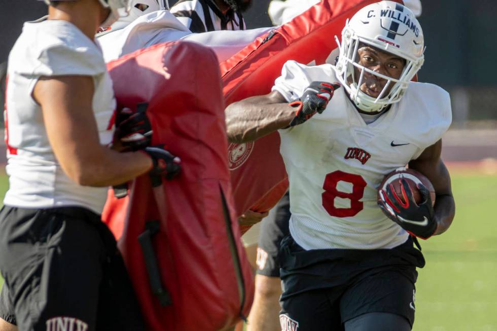 UNLV running back Charles Williams (8) hits a pad on a drill during football team practice at R ...