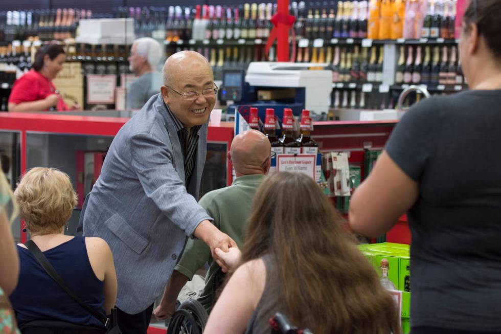 Hae Un Lee, founder of Lee's Discount Liquor, greets shoppers during the grand opening of the s ...