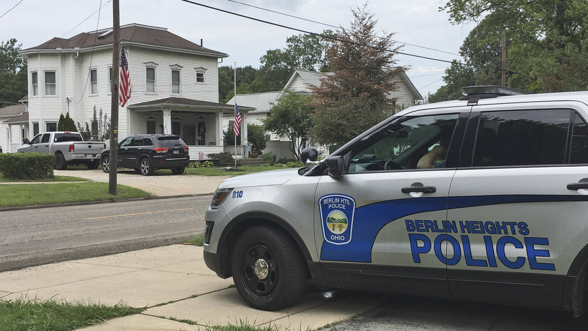 A Berlin Heights police officer sits across the road from the home of Maxton Soviak, Friday, Au ...