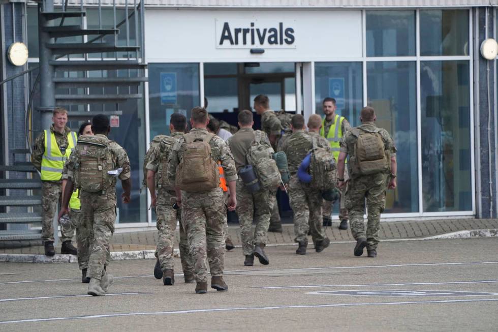 Members of the British armed forces 16 Air Assault Brigade walk to the air terminal after disem ...