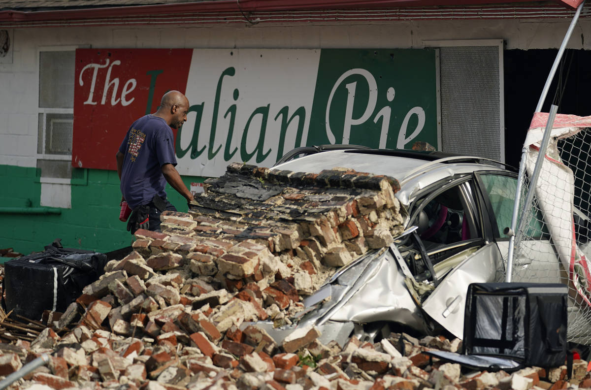 New Orleans Firefighters assess damages as they look through debris after a building collapsed ...