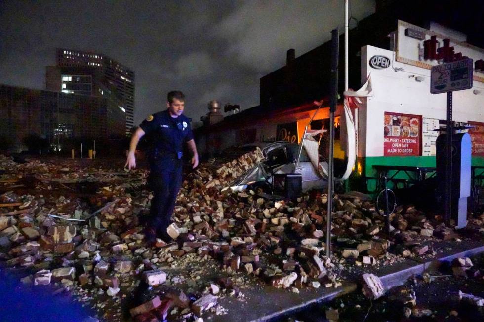 New Orleans Police detective Alexander Reiter, looks over debris from a building that collapsed ...