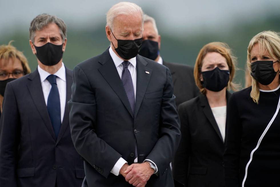 President Joe Biden bows his head as first lady Jill Biden, right, and Secretary of State Anton ...