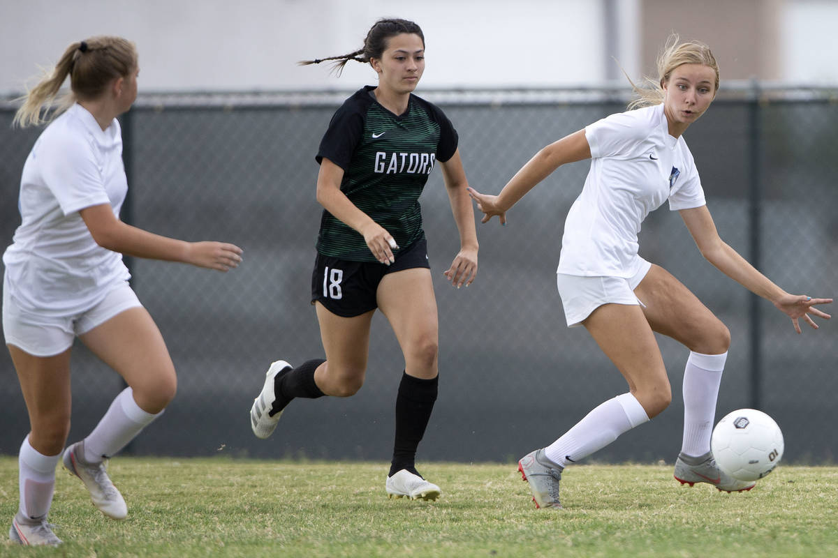 Foothill's Bailey Freeman (15) receives a pass while Green Valley's Brenna Knight (18) runs beh ...