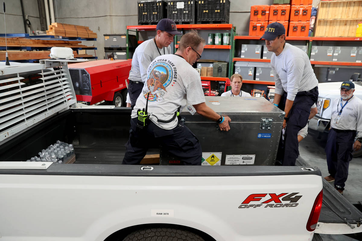 Members of the FEMA Nevada Task Force 1 Urban Search & Rescue team load equipment at their ...