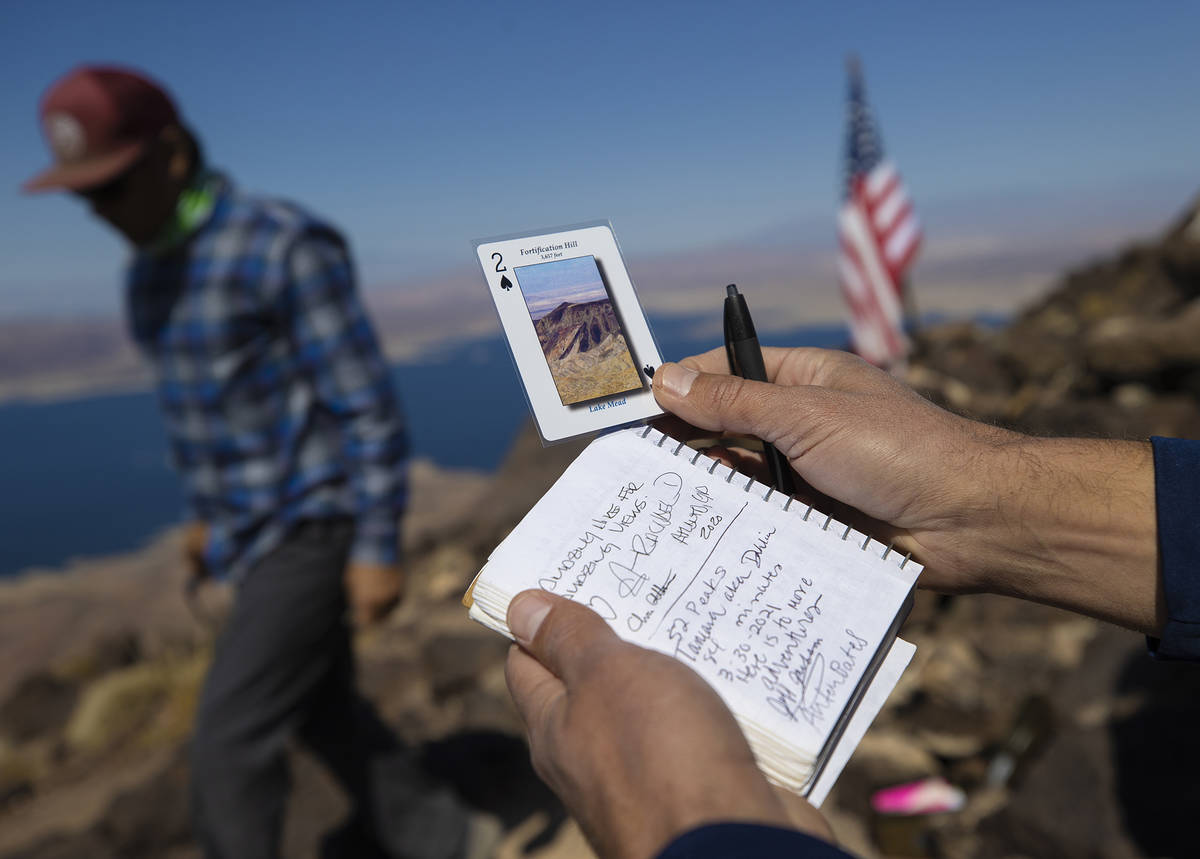 52 Peaks leader Jim Billetdeaux, right, gets hikers signatures and hands out cards at the top o ...