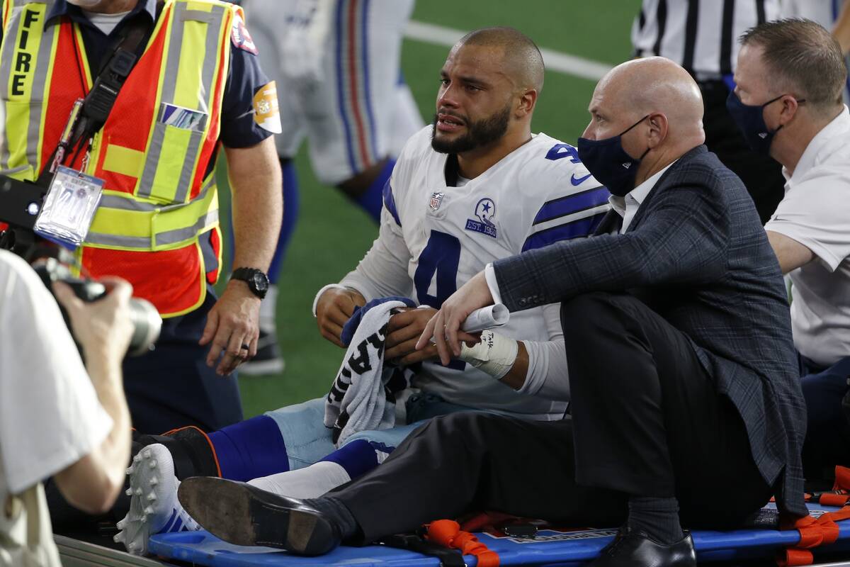 Dallas Cowboys quarterback Dak Prescott (4) is carted off the field by medical personnel after ...