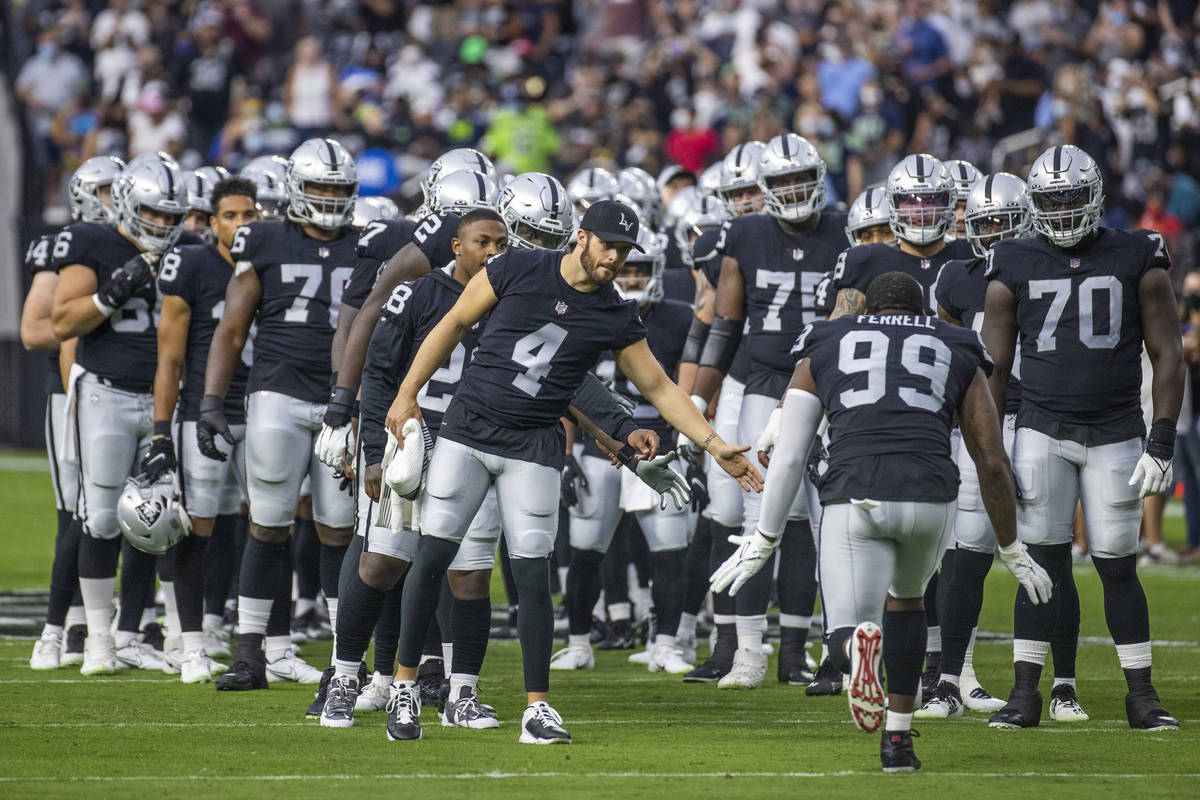 Raiders quarterback Derek Carr (4) and teammates welcome their starters to the field before the ...