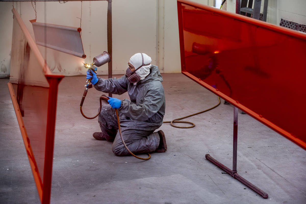 Jomar Reyes sprays red paint on the panels of Frank Pizarro's 1991 Pierce firetruck at Firetruc ...