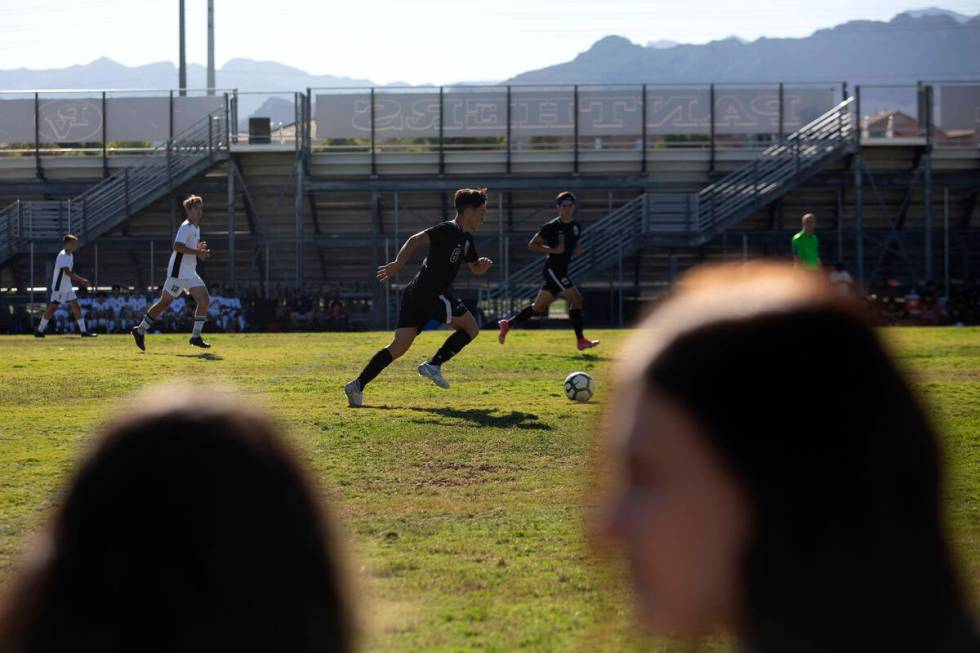 Palo Verde's Elad Cohen (8) makes way down the field while fans chat in the foreground during a ...