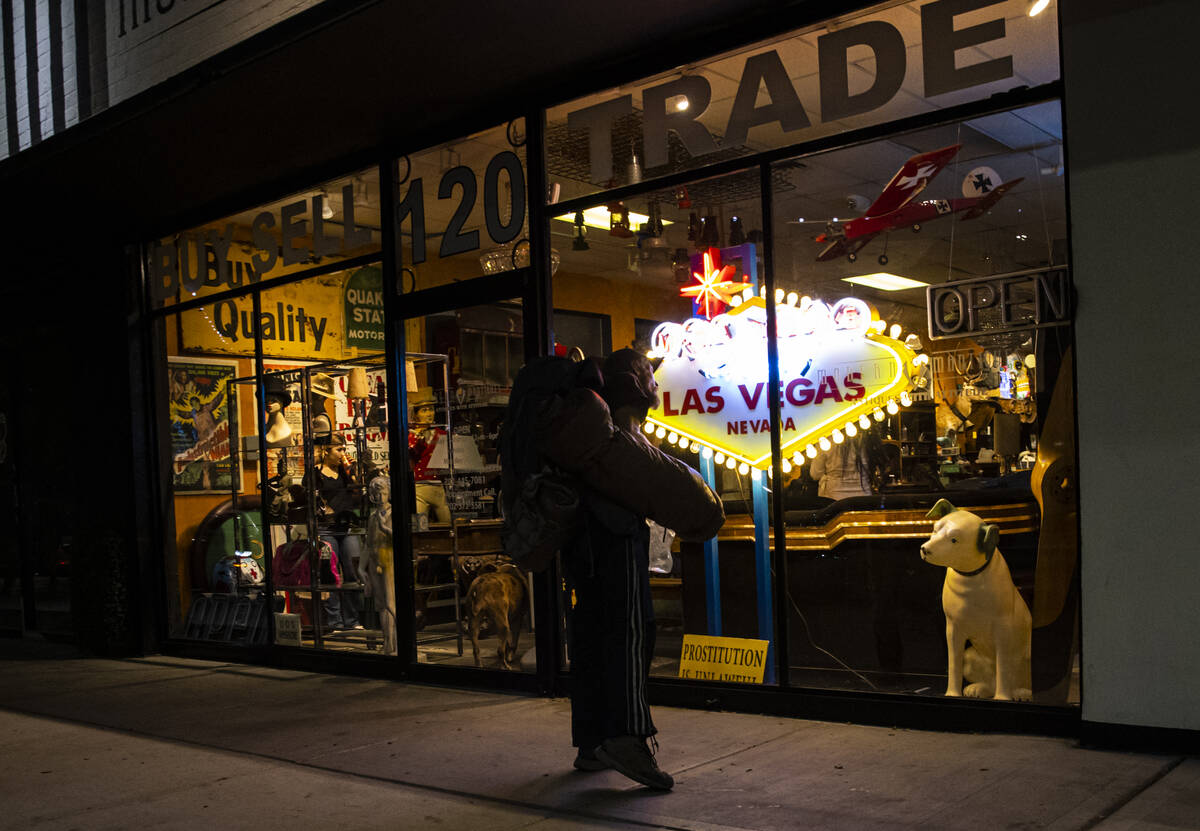 A passerby looks into Modern Mantiques on Main Street during First Friday in the Arts District ...