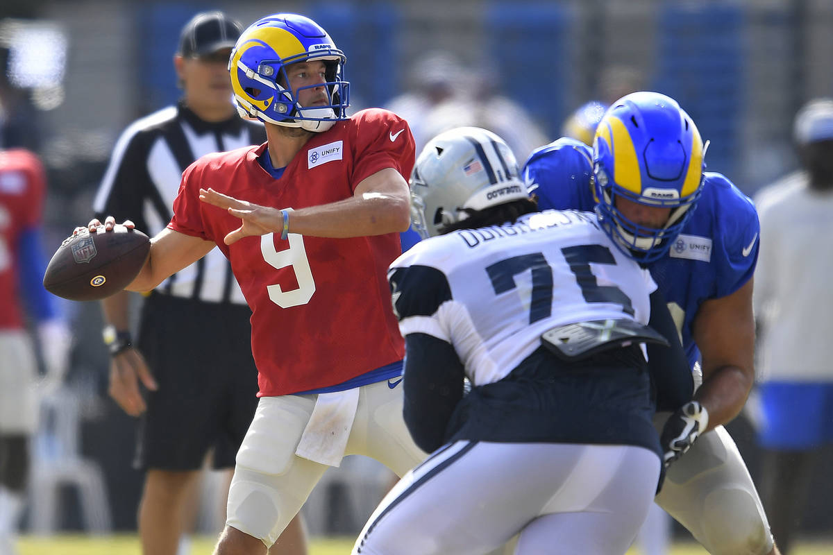 Los Angeles Rams quarterback Matthew Stafford looks for a receiver while Dallas Cowboys defensi ...