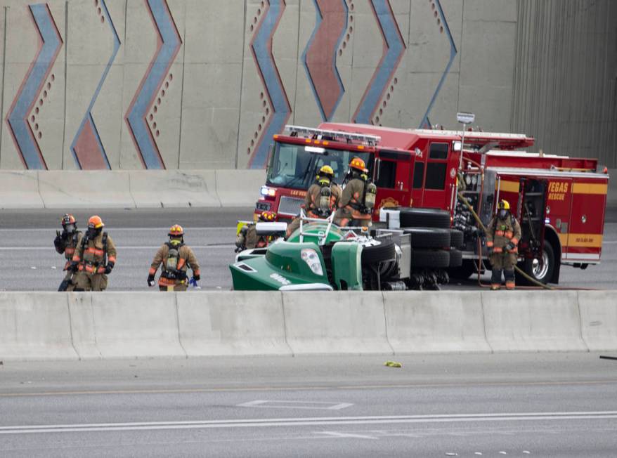 Emergency personnel work at the scene where a fuel tanker truck overturned on U.S. Highway 95 o ...