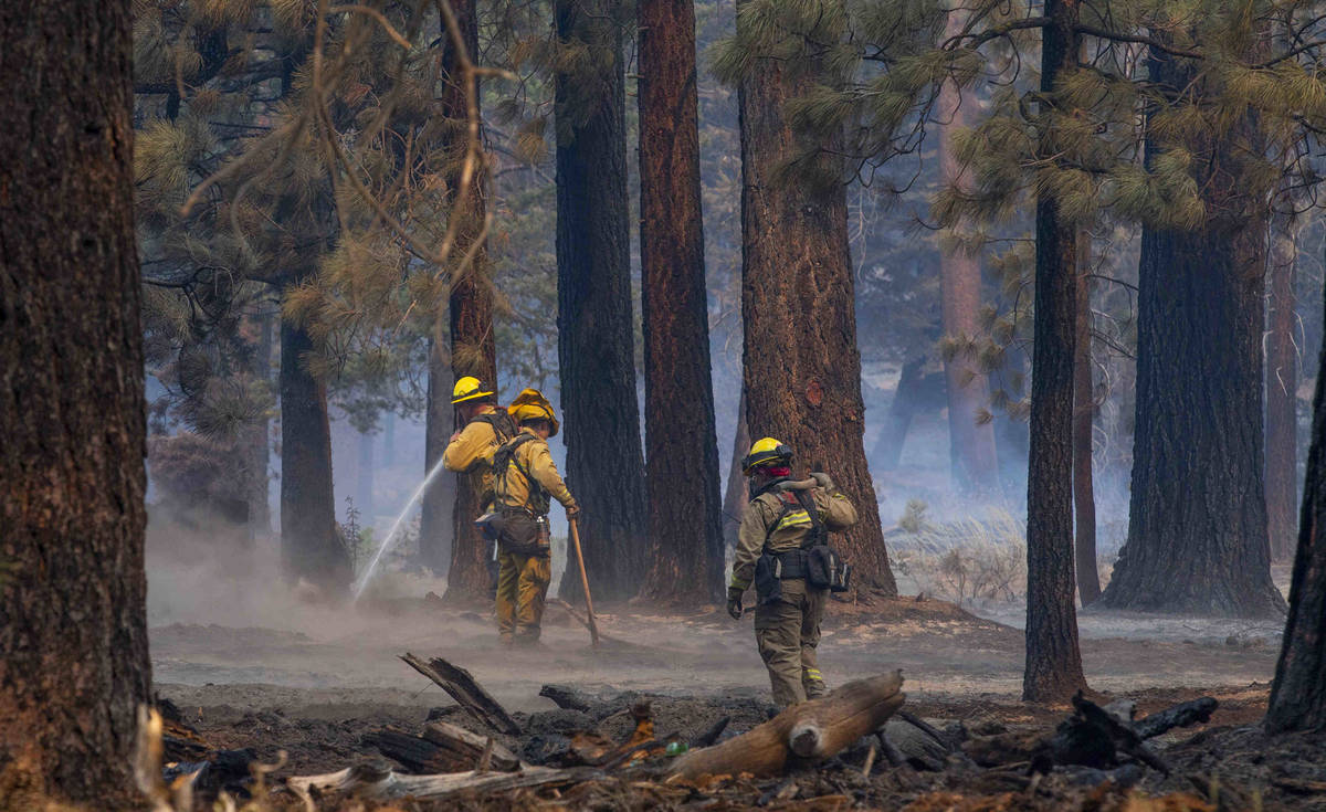 Firefighters mop up spot fires along SR 89 from the Caldor Fire on Wednesday, Sept. 1, 2021, in ...