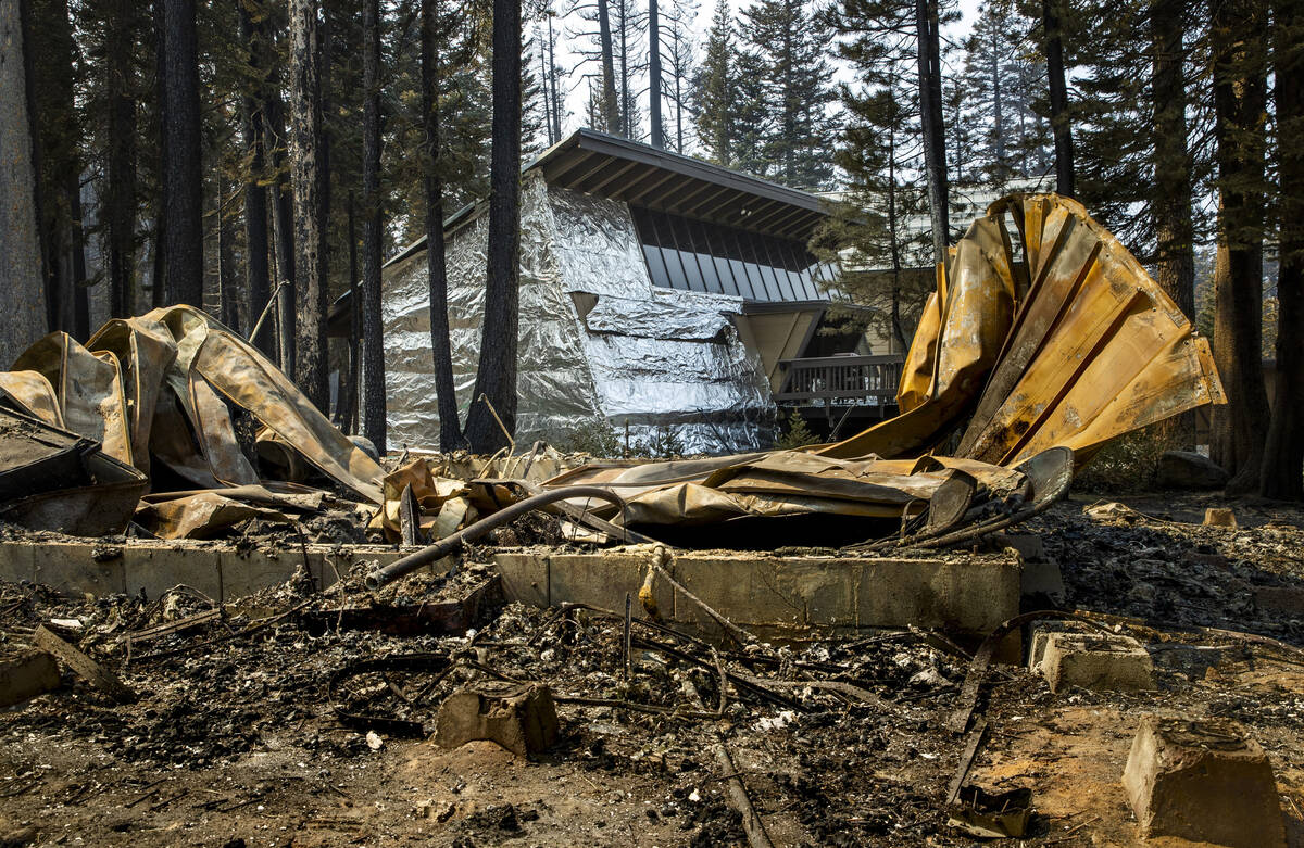 A home in the Phillips Park neighbor wrapped in tin foil is left untouched by the Caldor Fire a ...
