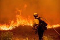 A firefighter battles the Caldor Fire along Highway 89, Tuesday, Aug. 31, 2021, near South Lake ...
