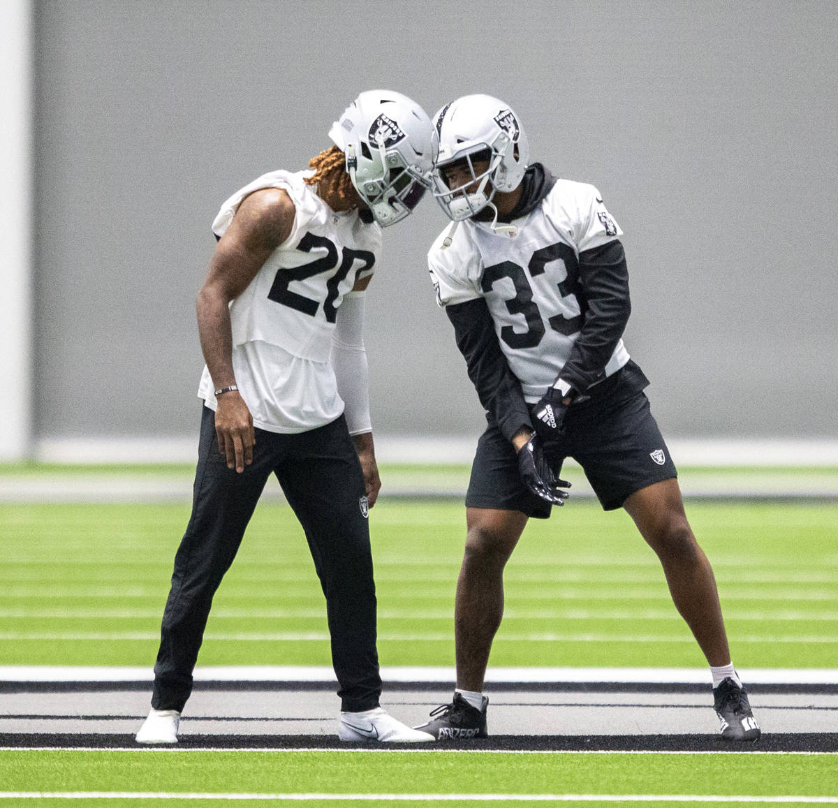 Raiders cornerback Damon Arnette (20) and safety Roderic Teamer (33) have a close conversation ...