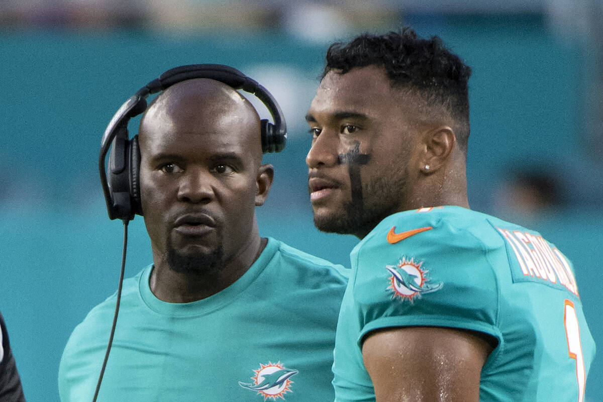 FILE - Miami Dolphins head coach Brian Flores, left, and quarterback Tua Tagovailoa (1) talk on ...