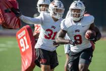 UNLV running back Charles Williams (8) runs past teammate Josh Tihada (31) after hitting a pad ...