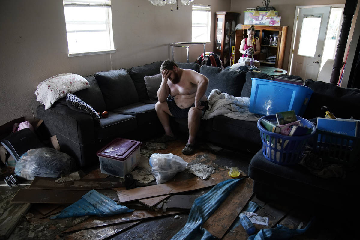 Josh Montford rests his head in his hand while going through his flood damaged home in the afte ...
