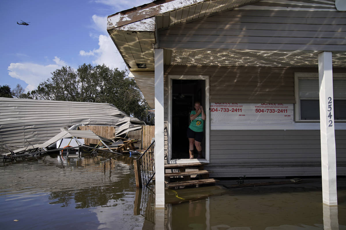 Natalie Francois make a call as she stands in the front door of her flooded home in aftermath o ...
