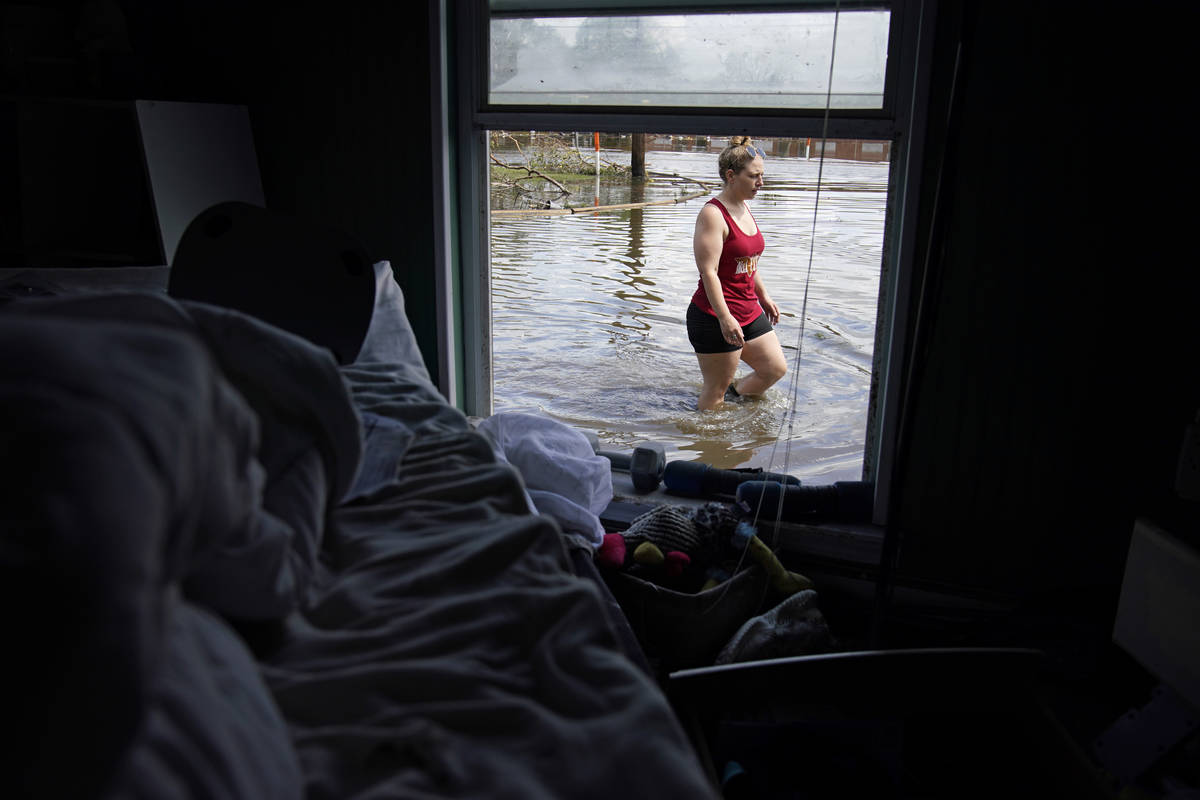 Emily Francois walks through flood waters beside her flood damaged home in the aftermath of Hur ...