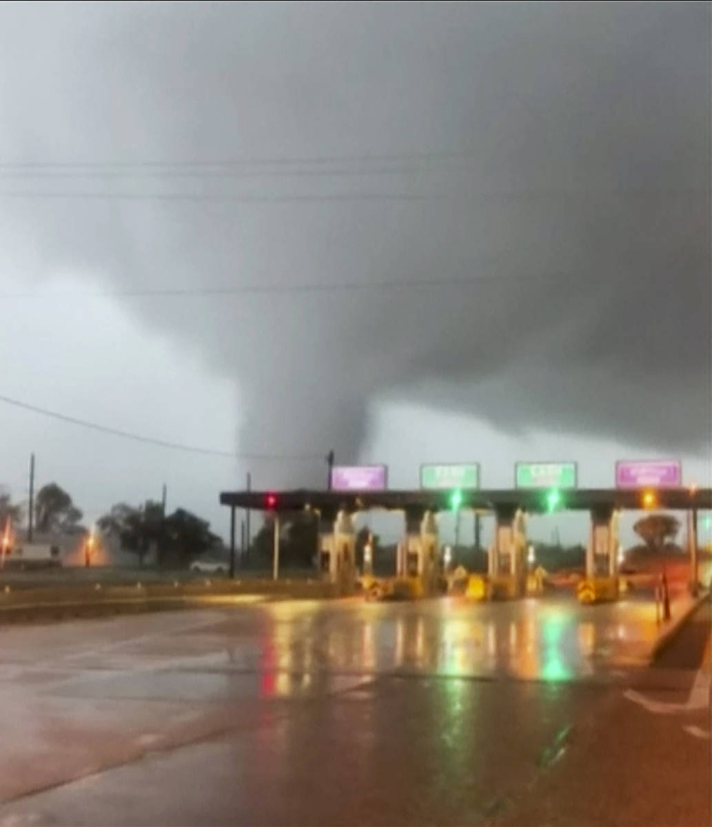 In this image taken from video provided by Scott Smith, a fast-moving tornado is seen in the di ...