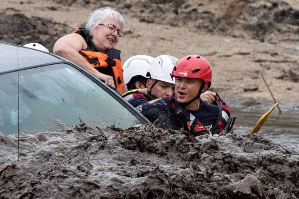 A woman climbs out of a pickup truck as Northwest Fire District firefighters position themselve ...