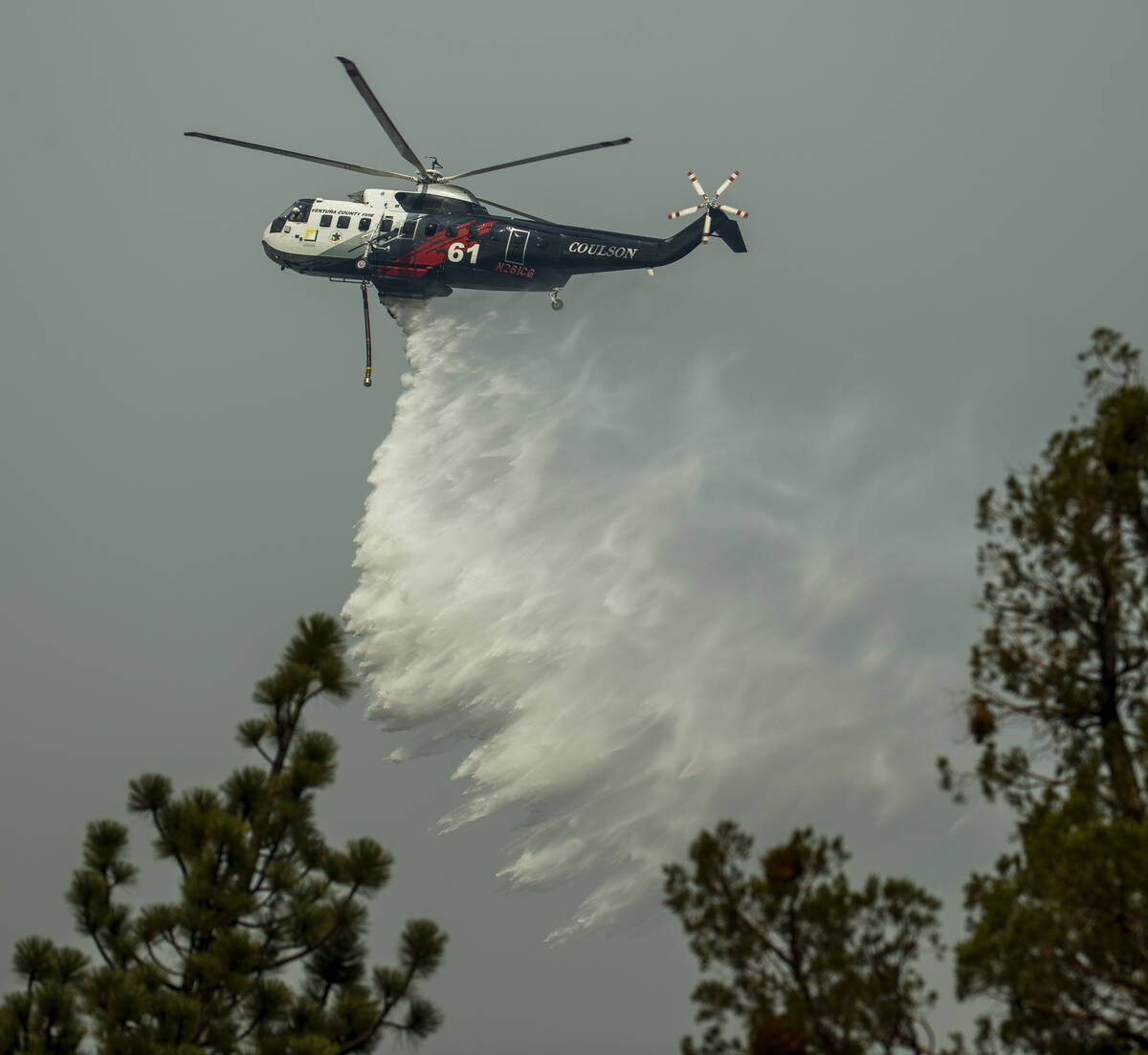 A helicopter from the Ventura County Fire department drops more water on the Caldor Fire on a r ...