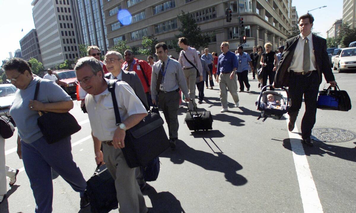 Workers leave buildings in the area near the White House in Washington on Sept. 11, 2001. The C ...