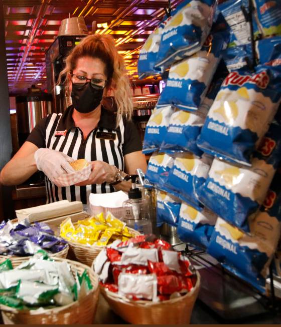 Snack Bar Attendant Loretta Maletto makes a hotdog for a customer at El Cortez in Las Vegas, Sa ...