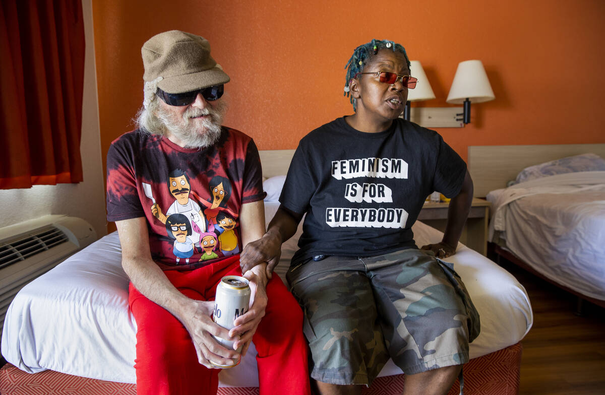Mr. Louis, left, who is legally blind, and caretaker Valerie Bridges sit and talk on a bed in t ...