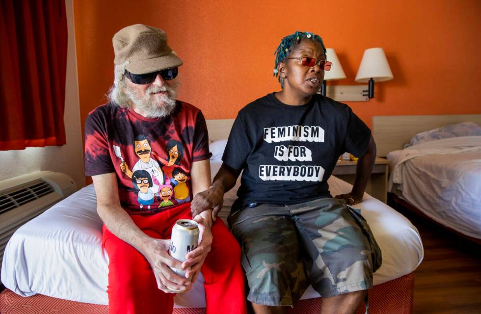 Mr. Louis, left, who is legally blind, and caretaker Valerie Bridges sit and talk on a bed in t ...