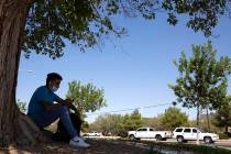 Bryan Vargas, a freshman at Rancho High School, takes refuge in the shade while waiting for the ...