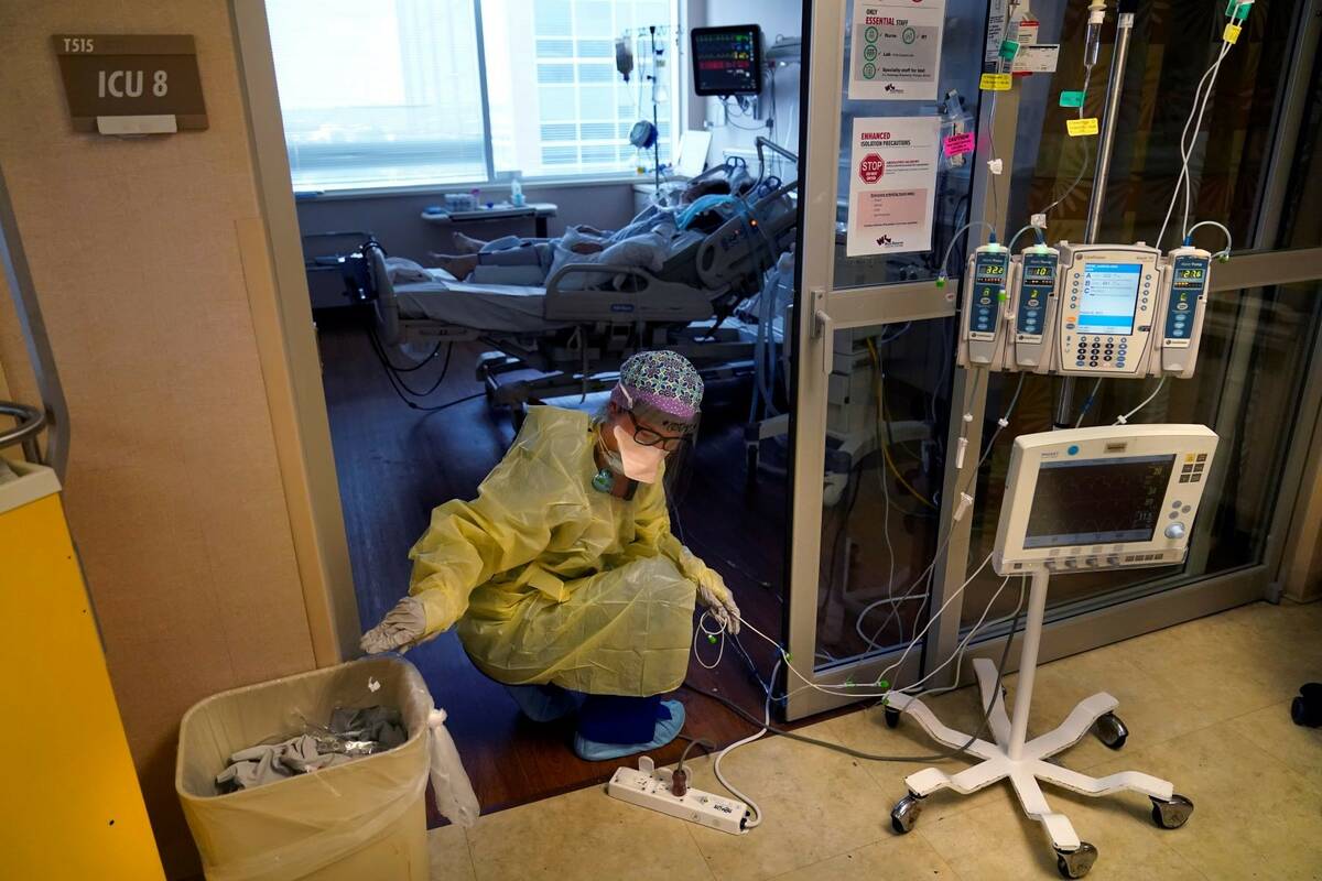An ICU nurse moves electrical cords for medical machines in an intensive care unit at the Willi ...