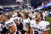 Montana quarterback Cam Humphrey lets out a yell as he celebrates with teammates after they bea ...
