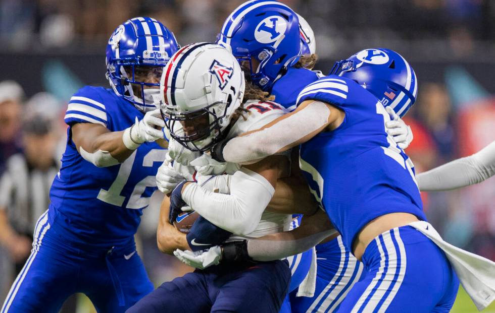 Arizona Wildcats wide receiver Tayvian Cunningham (11) is stacked up by BYU defenders in the th ...