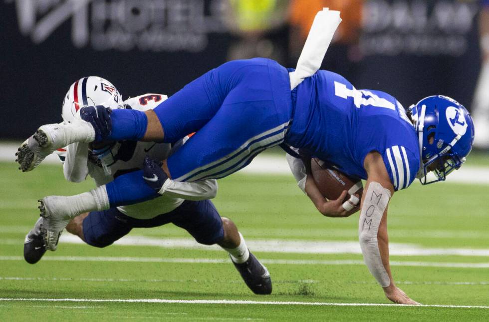 Brigham Young Cougars running back Lopini Katoa (4) is tackled by Arizona Wildcats safety Jaydi ...