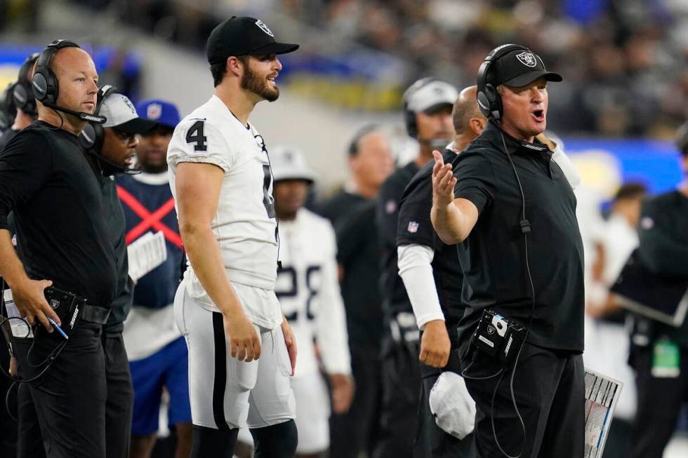 Las Vegas Raiders head coach Jon Gruden, right, argues a call in front of quarterback Derek Car ...