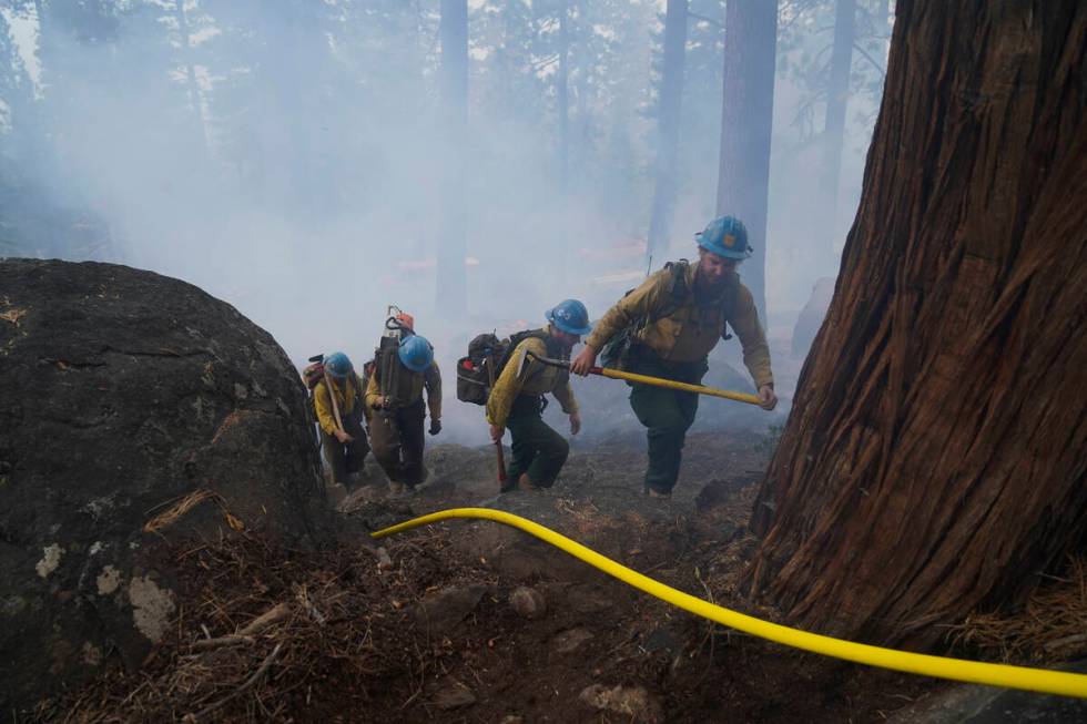 Members of a hotshot crew hike up the mountain while battling the Caldor Fire in South Lake Tah ...