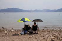 Beach-goers shade themselves under umbrellas along Boulder Beach at Lake Mead on Saturday, June ...
