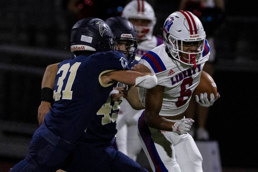 Liberty High wide receiver Marques Johnson (6) runs with the ball as Foothill High outside line ...