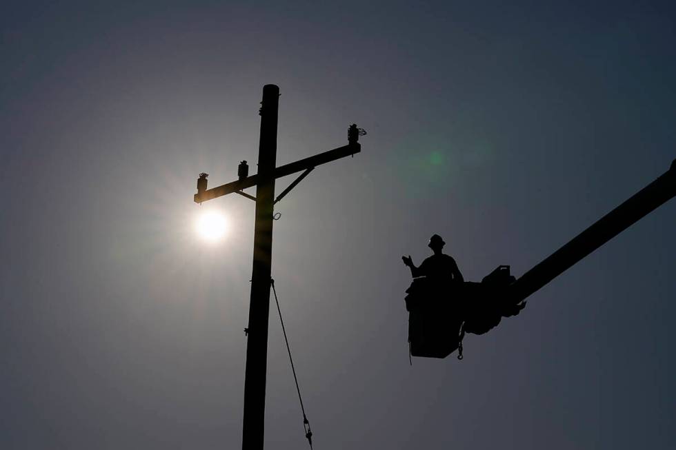 In the aftermath of Hurricane Ida, a lineman gestures as he works on a power pole, Sunday, Sept ...