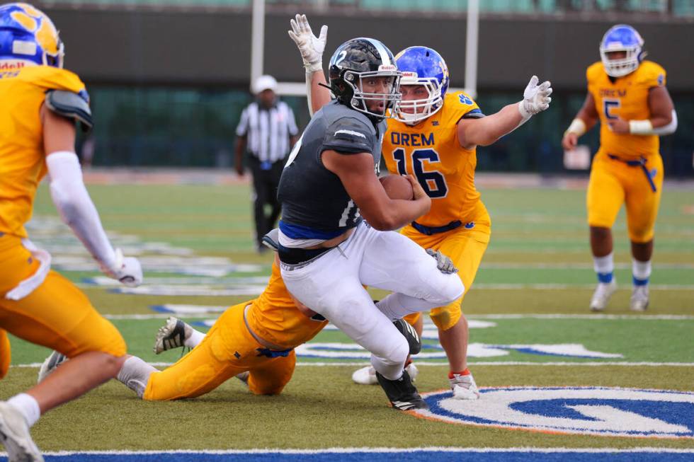 Desert Pines' Rjay Tagataese (12) runs for a touchdown under pressure from Hudson Dousette (16) ...