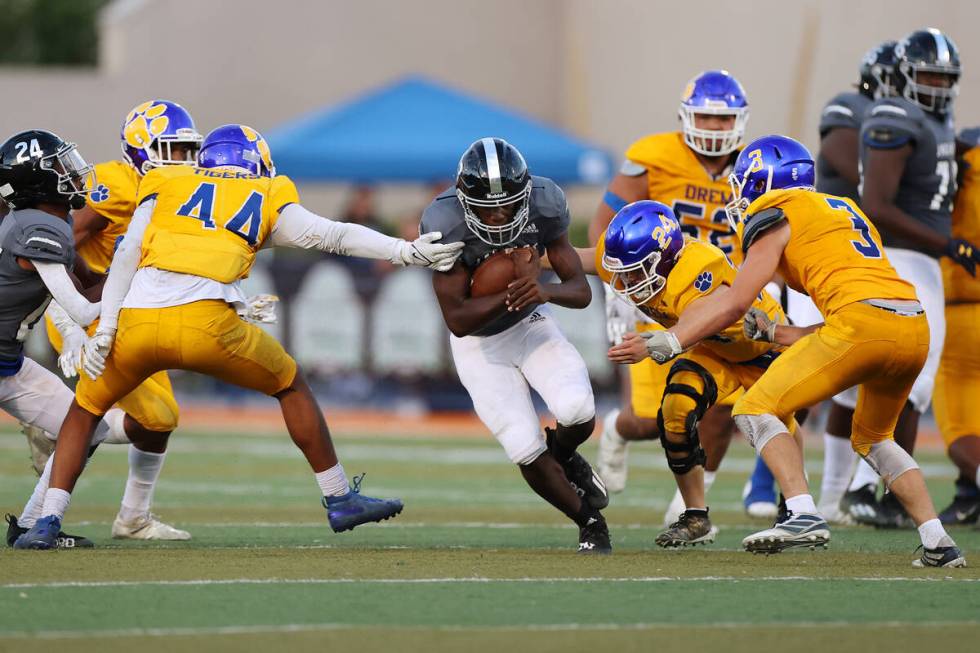 Desert Pines' Greg Burrell (23) runs the ball under pressure from Orem's Tim Toa (44), Matthew ...