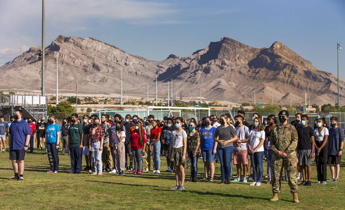 Students stand in honor during a ceremony to honor the memory of Palo Verde High School teacher ...